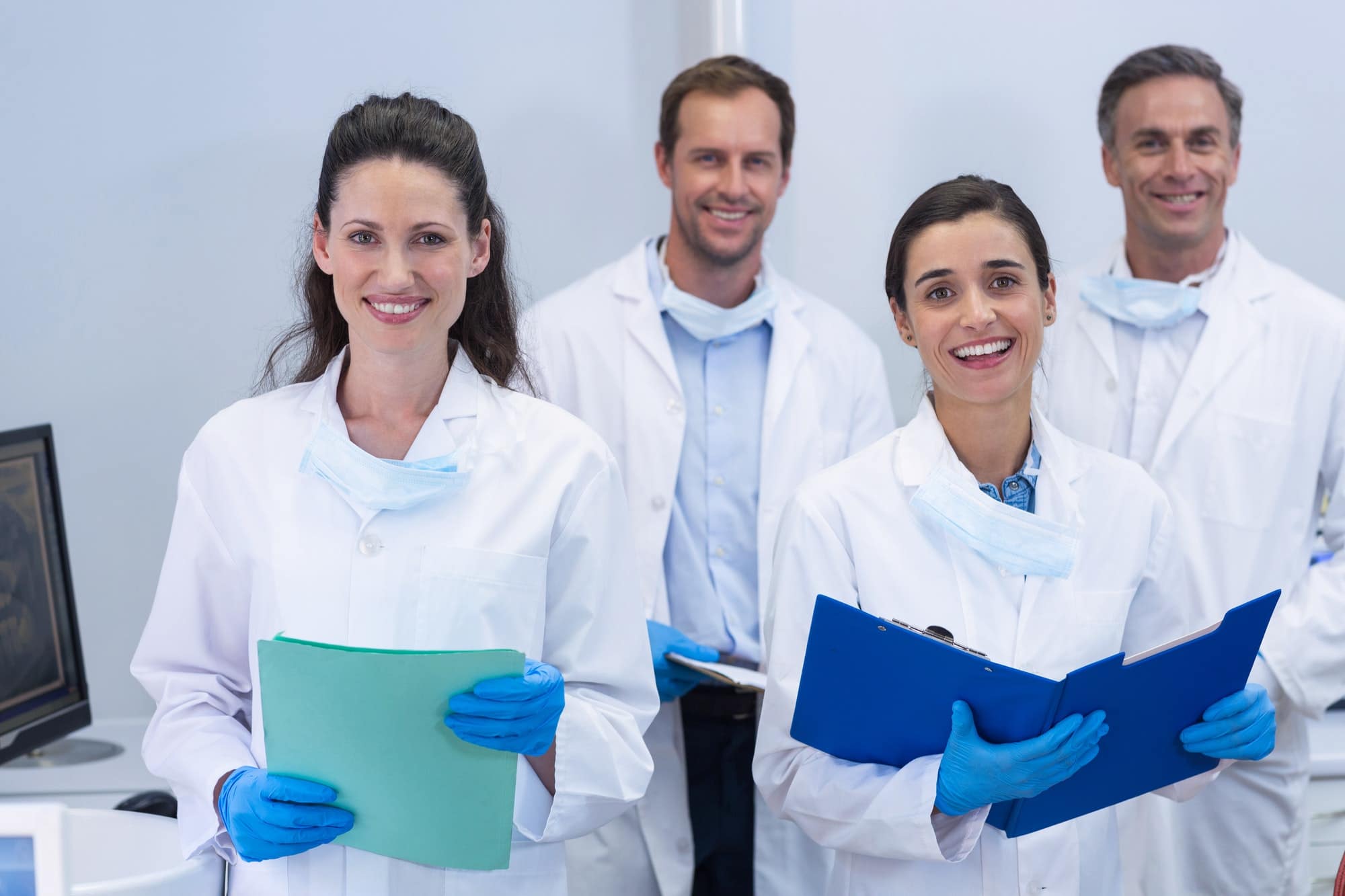 Smiling dentists standing in dental clinic