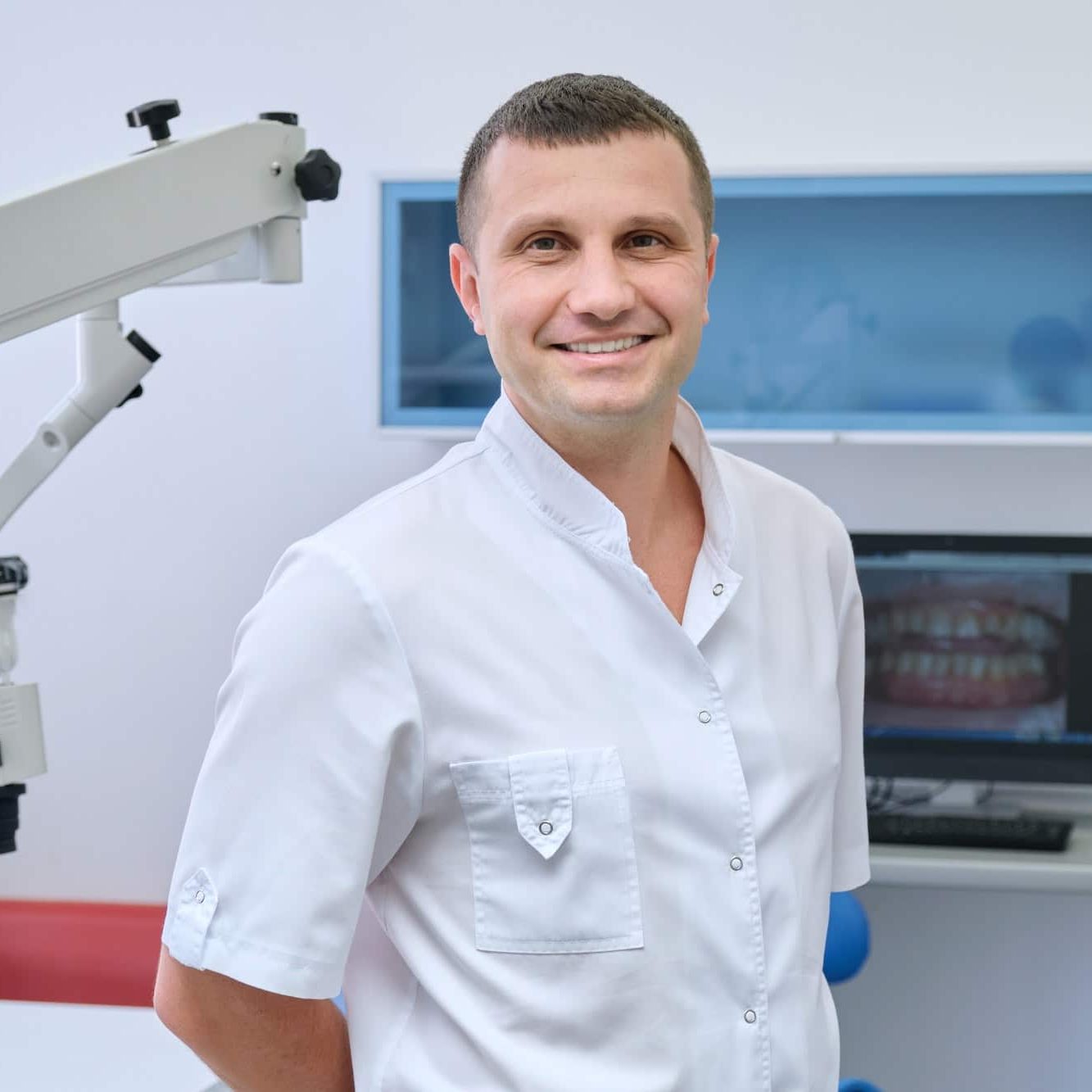 Portrait of happy friendly male dentist, doctor in dental clinic