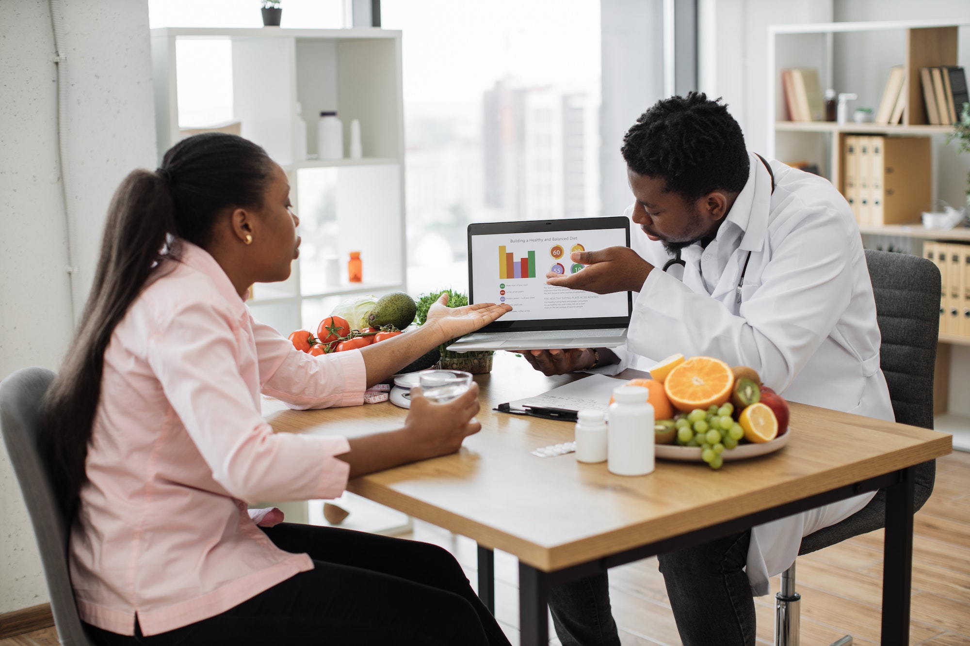 Doctor and patient analyzing treatment using online graphs